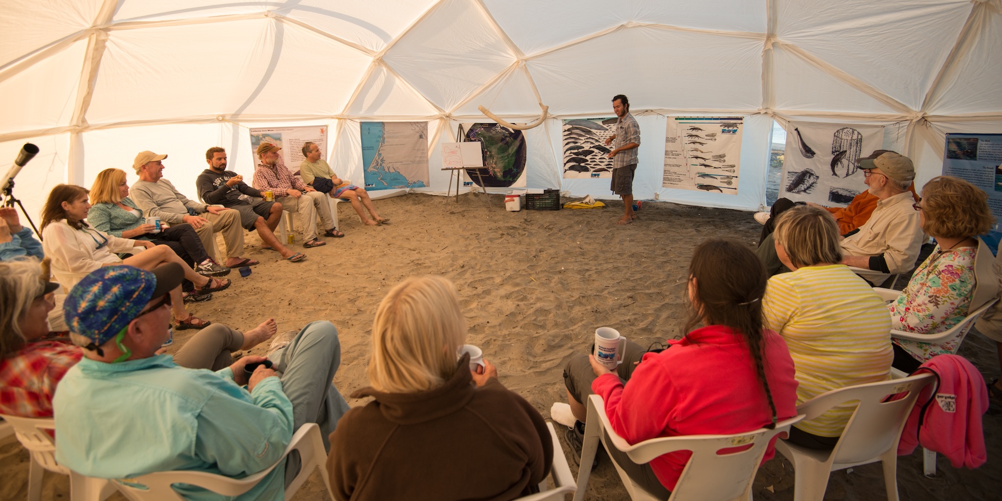 Naturalist guide leading a gray whale presentation at a beachside whale camp in Baja California