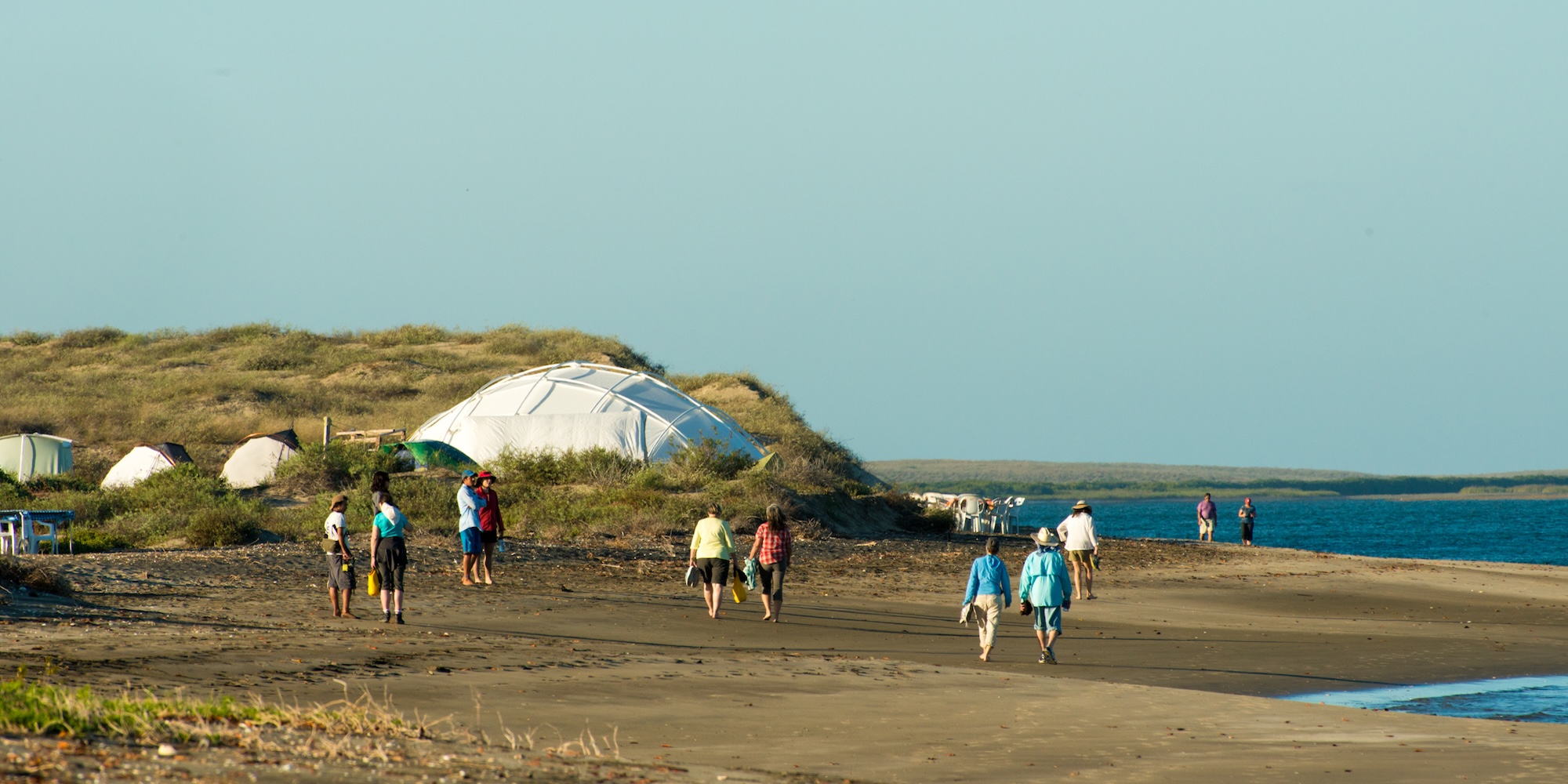 Guests walking along the beach near a remote whale camp in Baja California during whale watching season