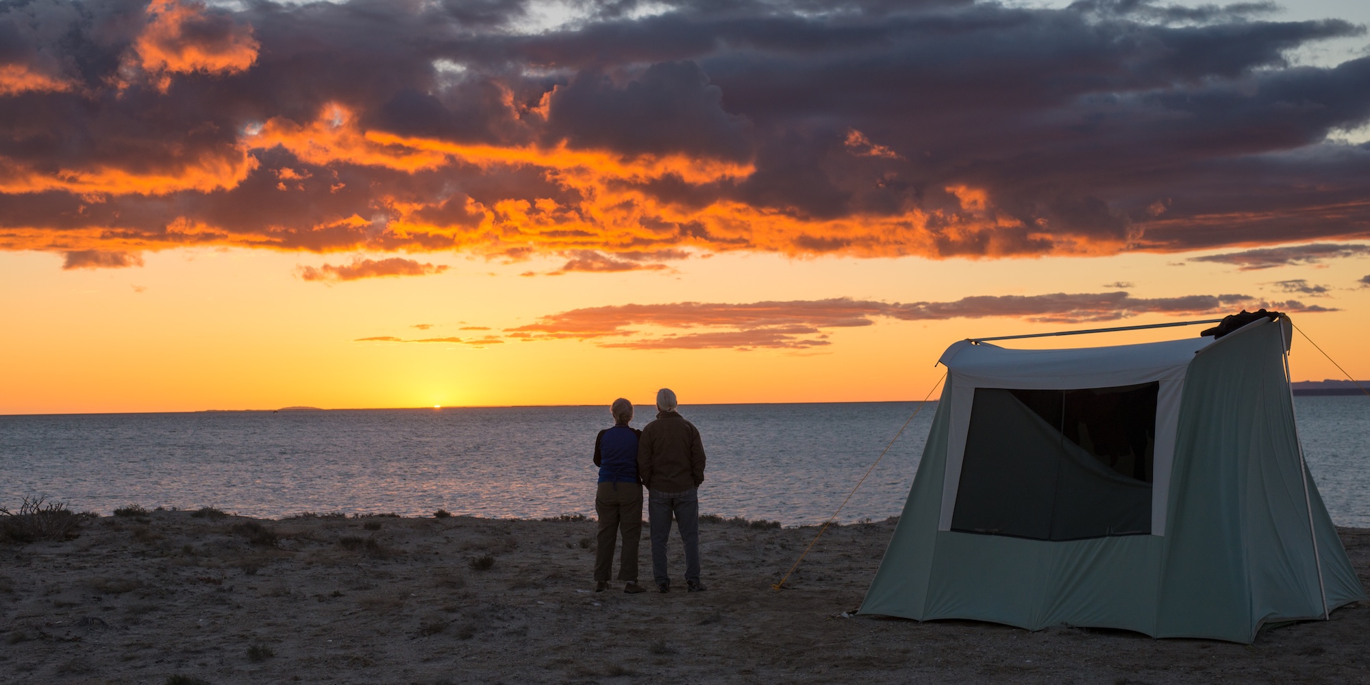 Guests watching the sunset near their tent at a remote whale camp in Baja California